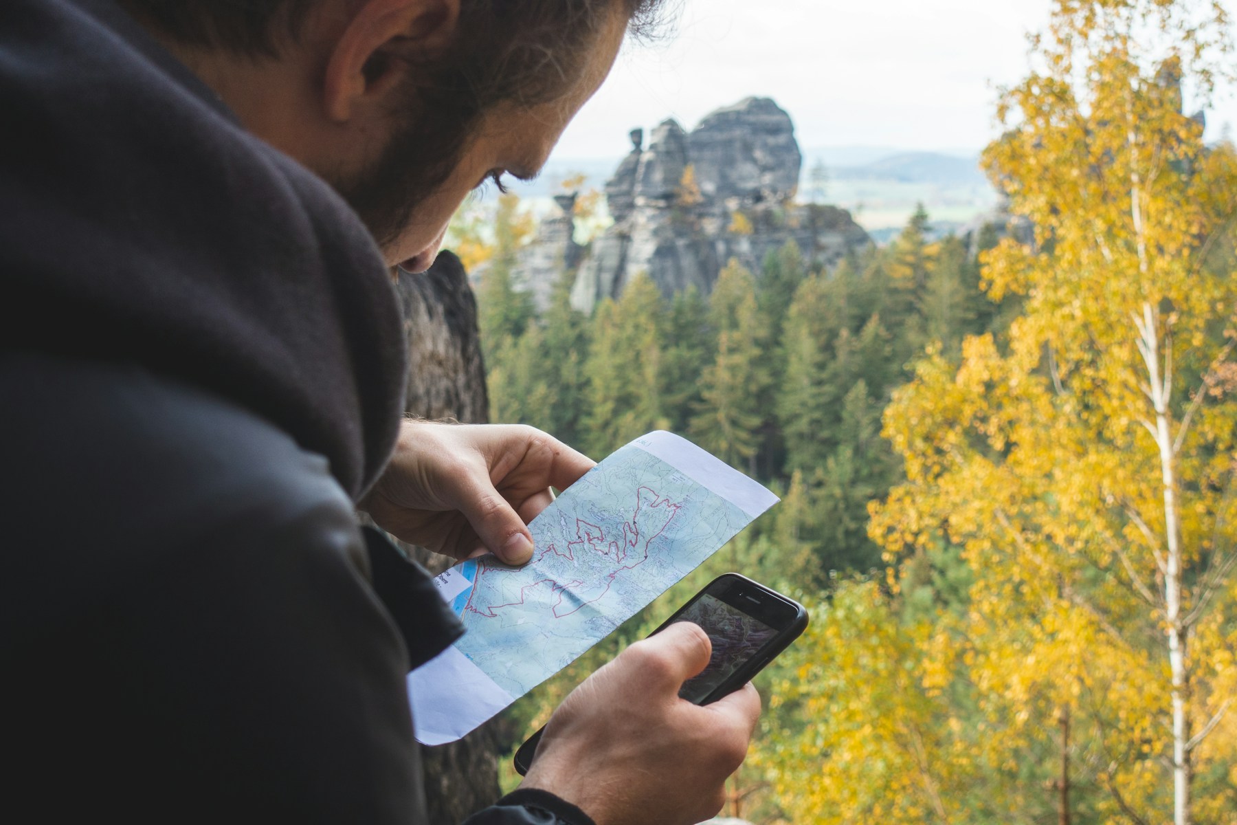 Viajero consultando un teléfono en un entorno de montaña