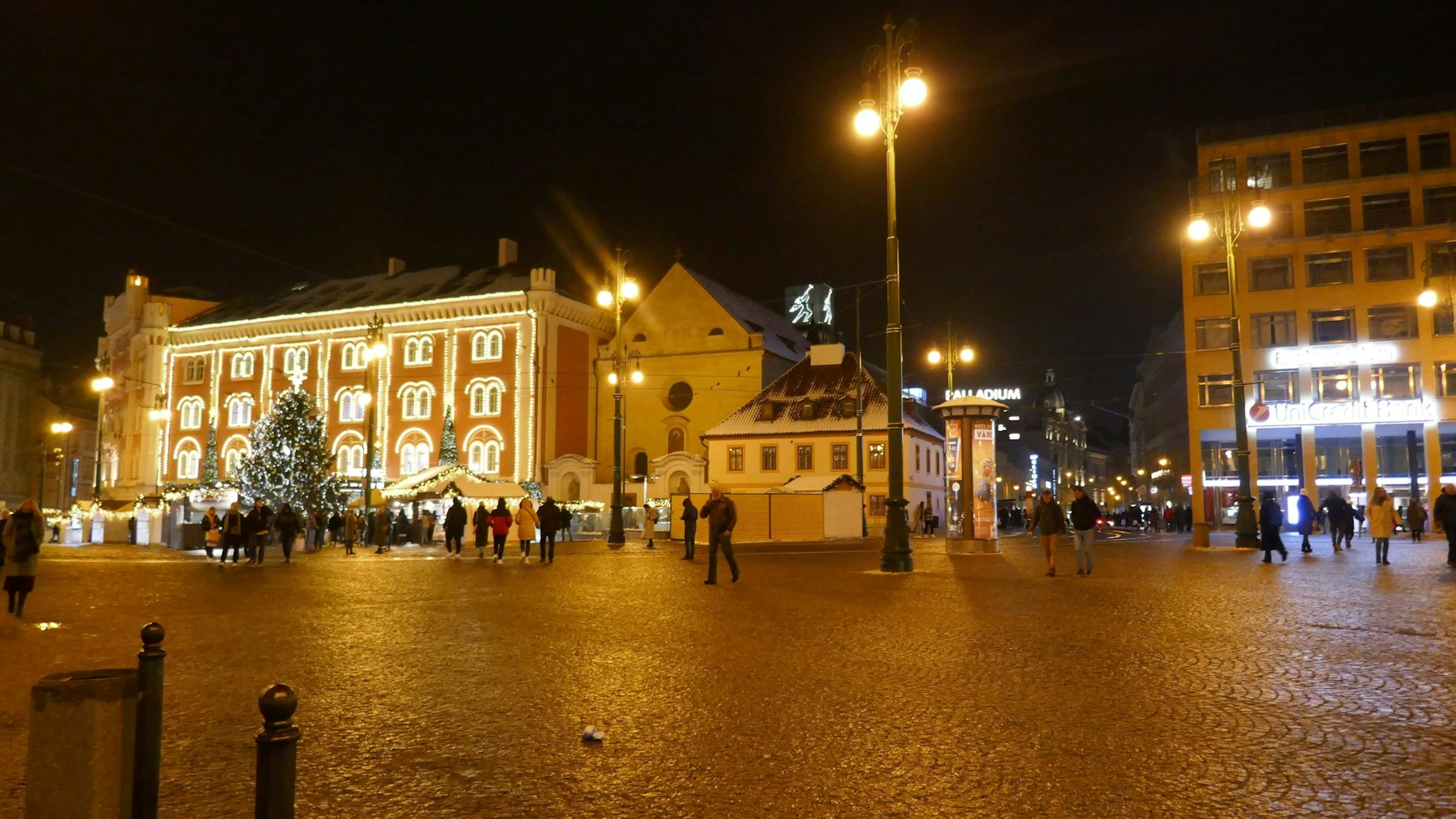 Plaza de Praga iluminada de noche con árbol y puestos navideños