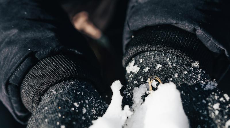 Manos con guantes sosteniendo nieve