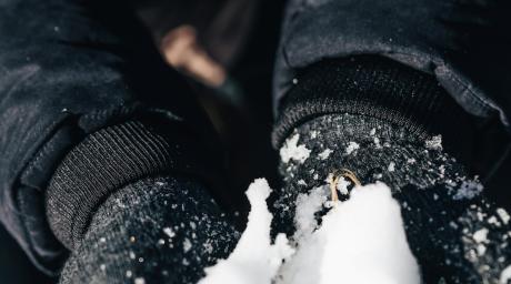 Manos con guantes sosteniendo nieve