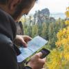 Viajero consultando un teléfono en un entorno de montaña