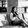 Viajera consultando su teléfono móvil en una terminal de aeropuerto